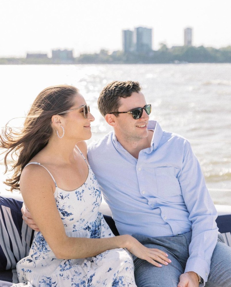 a man and woman sitting next to a body of water