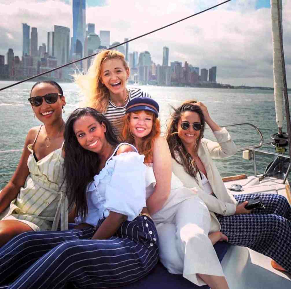 friends on a sailboat cruise NYC in the middle of the harbor